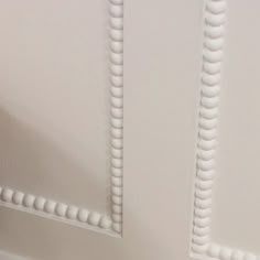 the corner of a white painted wall with beaded trim