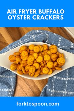 air fryer buffalo oyster crackers in a white bowl on a blue and white towel