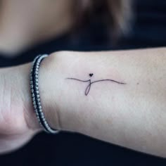 a woman's arm with a small tattoo on it that has an arrow in the middle