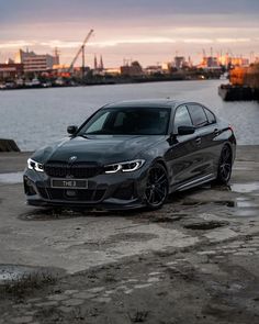 a grey car parked in front of a body of water