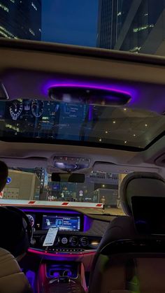 the interior of a car with city lights in the background