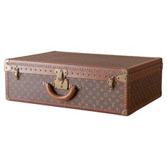 Louis Vuitton large ‘Alzer’ suitcase in LV monogram pattern coated canvas with edges trimmed in lozine and unpolished brass fittings. The lid of the case is secured by a central sprung catch with lock, plus two additional latches. Cream coated canvas lining to the interior and a removable tray with two fabric straps. Circa 1995. Dimensions: 70 cm/ 28 inches (width) x 47cm/ 18 inches (depth) x 22cm/ 9 inches (height). Louis Vuitton was founded by its namesake in 1854, with the first shop on Rue N Louis Vuitton Luggage, Cream Coat, Color Crema, Monogram Pattern, S Monogram, Lv Monogram, Coat Patterns, Brass Fittings, Luxury Travel