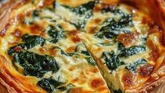 a cheese and spinach quiche on a cutting board