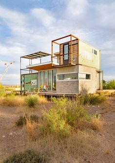 a house made out of shipping containers in the desert