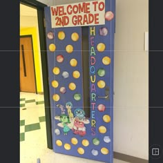 a sign that says welcome to 2nd grade in front of a door decorated with cartoon characters