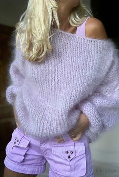 a blonde woman wearing purple shorts and a sweater