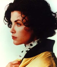 a close up of a person wearing a yellow jacket and polka dot collared shirt