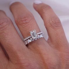 a woman's hand with a diamond ring on top of her finger and an engagement band