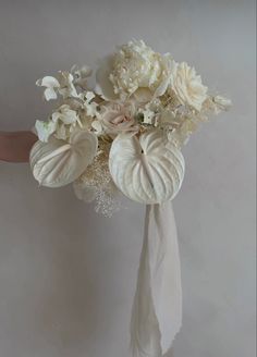 a bridal bouquet with white flowers and feathers