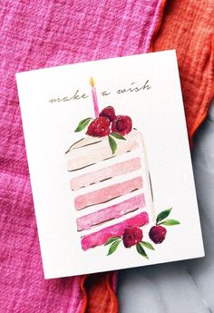 a piece of cake on top of a pink towel next to a card that says make a wish