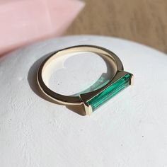 A slim band topped with a long baguette cut, emerald green colored crystal that's subtle but stunning. Wear this solo or stacked alongside your favorite rings.  Crystal: 13mm x 3mm. Band: 1mm.  Our materials make for an amazing, high quality, seamless, jewelry piece with longevity. Our rings are plated with 18k gold, 18k rose gold, or sterling silver and finished with a protective coating. A little secret we'll keep between us: it looks way more than it costs. Emerald Baguette Ring, Rings Crystal, Baguette Ring, Rick Rack, Delicate Jewelry, Baguette Cut, Gift List, Spring Green, Favorite Rings