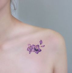 a woman's chest with purple flowers on it, and one flower in the middle