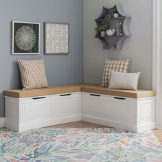 a corner bench with storage underneath it in a room that is painted blue and white