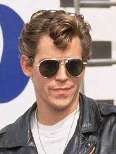 a man wearing sunglasses and a leather jacket