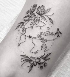 a world map with flowers on it and an airplane flying over the earth in black ink