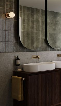 a bathroom with two sinks and mirrors on the wall