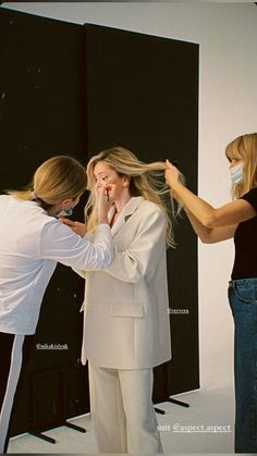 two women are brushing their hair in front of a mirror