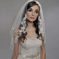 a woman in a wedding dress with a veil on her head is posing for the camera