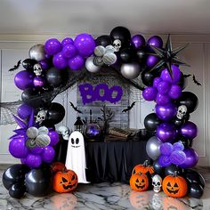 an arch decorated with balloons and decorations for a halloween themed party in purple, black and white