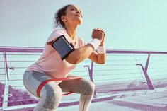 a woman in pink shirt and leggings holding a book while standing on top of a