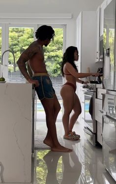 two people standing in a kitchen near an oven