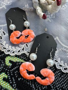 two pairs of earrings on top of a table