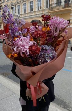 a woman holding a bouquet of flowers on the street