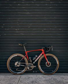 a red bike parked in front of a garage door