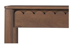 a wooden headboard with scalloped details on the top and bottom edge, against a white background