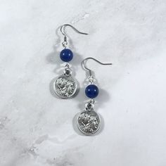 These Athena earrings are the perfect accessory to show your love for the Greek gods in a subtle way! Made with sodalite gemstone and a Greek coin replica charm featuring the goddess Athena. Made with fishhook style earrings. I offer both a standard and hypoallergenic option for the hooks. The standard is stainless steel and the hypoallergenic is 925 sterling silver plated. Ships in a jewelry box so it's ready to be give as a gift. All materials are lead and nickel free. Charm is made with zinc alloy.  Earrings will be disinfected before shipment but should also be cleaned every time before wearing. Goddess Greek, The Greek Gods, Greek Mythology Jewelry, Mythology Jewelry, Goddess Athena, Athena Goddess, Greek Coins, Hippy Gifts, Alloy Earrings