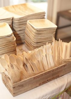 wooden spoons are stacked in a box on a table