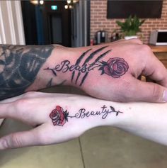 two people with matching tattoos on their arms holding each other's hands and the words beauty written in cursive font