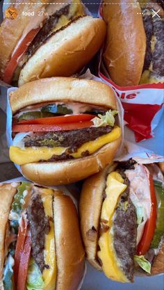 several hamburgers with cheese, tomatoes and peppers are stacked on top of each other