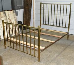 a metal bed frame with wooden slats in a garage next to a garage door