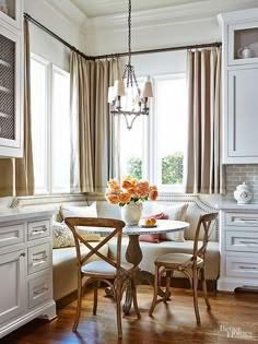 a dining room table and chairs in front of a window