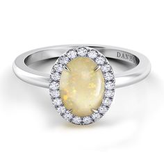 a white gold ring with an oval opal and diamond halos on the band