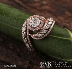 a diamond ring sitting on top of a leaf