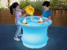 two children playing with an inflatable water fountain