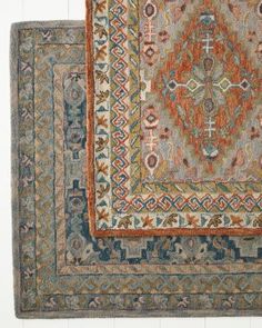 two rugs, one with an orange and blue design on the bottom right hand side