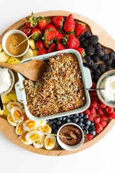 a platter filled with fruit, dips and other foods on top of it