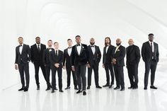 a group of men standing next to each other in tuxedos