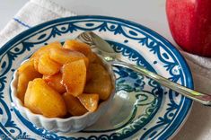 a bowl filled with apples on top of a blue and white plate