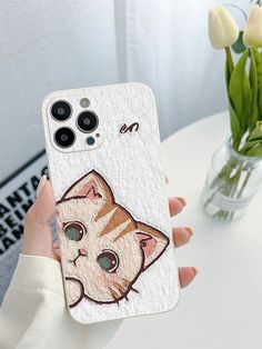 a person holding up a phone case with an image of a cat on it