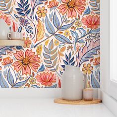 the wallpaper in this kitchen is painted with colorful flowers and leaves, along with two vases