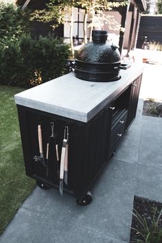 an outdoor bbq with grill and utensils on it