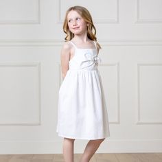 Your girl will be a summer stunner in our flowy sundress, styled with a pretty bow front detail and cut from our soft organic cotton and linen blend. Features adjustable button straps and an elastic bodice for a comfortable fit. Fully lined in organic cotton. A light and fresh look she will love. 55% Linen, 45% Organic Cotton, exclusive of trims. Garment is OCS-Certified. Fully lined in organic cotton. Adjustable button straps. Elastic at the back bodice. Machine washable. Hope & Henry is an Ame Spring Beach Dress With Bow Detail, Spring Beach Dress With Bow, Casual Cotton Dress With Bow Straps, Beach Cotton Dress With Bow Tie Back, Summer Cotton Sundress With Knotted Straps, Sleeveless Cotton Dress With Bow, White Vacation Dress With Bow Detail, White Vacation Dress With Bow, Spring Cotton Dress With Bow Straps