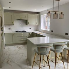 a kitchen with marble counter tops and gold bar stools in front of an island