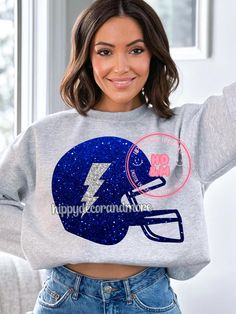 a woman wearing a sweatshirt with a football helmet on it