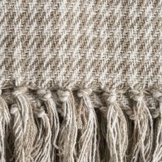 closeup of the fringes on a woven fabric textured with woolen yarn