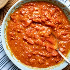 a bowl filled with red sauce on top of a table